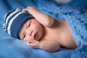 Baby Junge liegt entspannt in einer Decke ©iStockphoto, Thinkstock